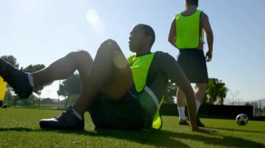 Top kontrolü, futbol oyuncusu güneşli sahada parlak yelek giyiyor. eğitim, atletizm, spor, egzersiz, futbol, açık hava