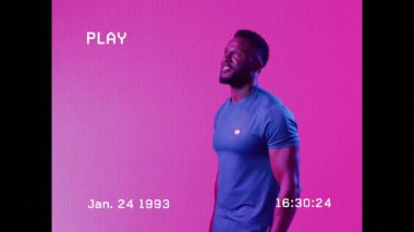 Elinde tenis raketi, canlı pembe arka plana karşı tutkuyla kutlama yapan bir adam. Kutlama, spor, atlet, zafer, enerjik, maç