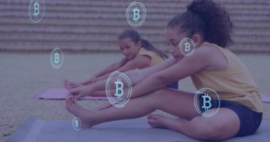 Okulda çocuklar yoga minderleri üzerinde Bitcoin sembolleri olan animasyonlarla esniyorlar. Kripto para birimi, meditasyon, dijital para birimi, rahatlama, teknoloji, egzersiz