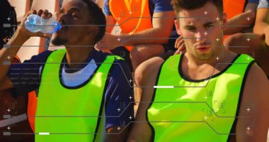 Açık tribünlerde oturan parlak yelekli genç sporcular verileri animasyonla örtüyor. Spor, takım çalışması, rekabet, teknoloji, dijital, açık hava