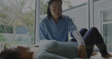 Fizik tedavi uygulamalarında yardımcı olmak, büyük pencerelere yakın bir sağlık uzmanı. Fizyoterapi, rehabilitasyon, tedavi, sağlık