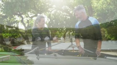 Kürek çekme ekipmanları hazırlanıyor. Manzaralı nehir manzarası animasyonu yapan iki kişi. Hazırlık, takım çalışması, doğa, macera, aktivite, fitness