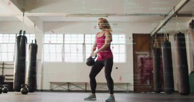 Spor salonunda, veri işleme animasyon kaplamalı kettlebell kaldıran bir kadın. Spor, güç, egzersiz, teknoloji, dijital, egzersiz