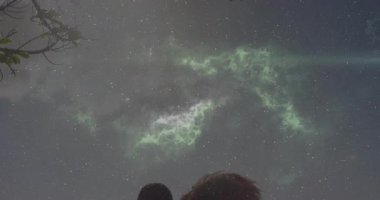 Yeşil aurora ve yıldızları gözlemlemek, siluetli insanların gece bir arada durması. Aurora borealis, yıldız gözleme, siluetler, gece gökyüzü, göksel, atmosferik