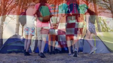 Çadırların yanında duran, sırt çantalı bir grup arkadaş Hırvat bayrağı taşıyor. Macera, seyahat, kamp, yürüyüş, arkadaşlık, vatanseverlik