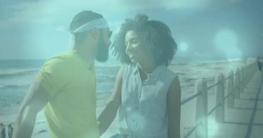 Sahilde yürürken, güneş ışığı alan bir çift, neşe dolu anlarını paylaşıyor. Romantizm, mutluluk, bağ, doğa, aşk, rahatlama