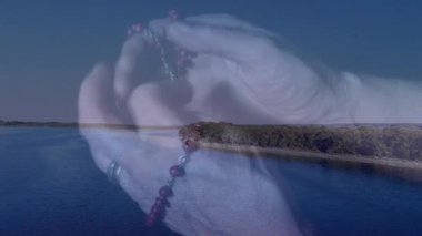 Huzurlu göl ve ormanın üzerinde tespih taşıyan kişi animasyonu takdir ediyor. Doğa, meditasyon, maneviyat, bağlılık, sükunet, rahatlama.