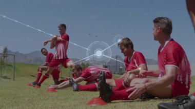 Futbolcular ağ bağlantıları ile sahada esneme hareketleri yapıyorlar. Takım çalışması, spor, egzersiz, teknoloji, dijital, sporcular