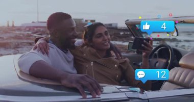 Üstü açılabilir plajdaki çift sosyal medya bildirimleriyle meşgul oluyor. Tatil, seyahat, yaz, okyanus, özgürlük, yaşam tarzı