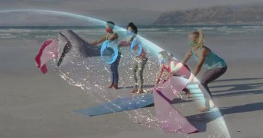 İnsanlar plajda dijital ağ animasyonu eşliğinde yoga minderleri kuruyor. Meditasyon, farkındalık, sağlık, teknoloji, rahatlama, egzersiz