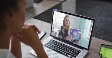 Okulda, animasyon, meslektaşlarını bilgisayardaki video konferansında veri sunarken gösteriyor. Toplantı, sunum, işbirliği, teknoloji, iletişim, dijital