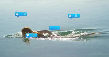 Suda yüzen, sosyal medya bildirimleriyle çevrili biri. Dijital, internet, bağlantı, sanal, iletişim, teknoloji