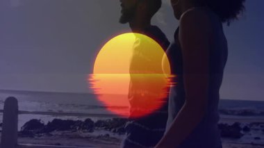 Canlı günbatımı animasyonlarıyla sahilde yürüyen siluetli bir çift. Romantik, akşam, huzur, rahatlama, tatil, manzara