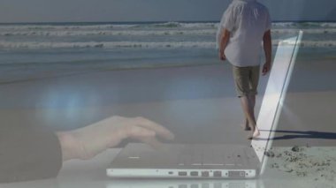 Sahilde dizüstü bilgisayarında dijital ağ animasyonuyla yürüyen bir adam. Teknoloji, yenilik, iletişim, bağlantı, açık hava, çalışma