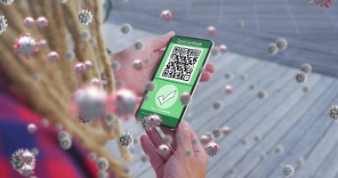 Ekranda QR kodlu akıllı telefonu tutan kadının üzerinde yüzen covid-19 hücrelerinin bileşimi. covid-19 aşı sertifikası ve sağlık kartı konsepti
