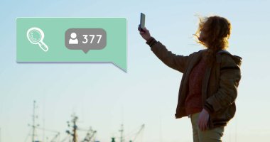 Numaralar, sosyal medya simgeleri ve akıllı telefon kullanan bir kadının konuşma balonu görüntüsü. küresel sosyal medya ve bağlantılar konsepti dijital olarak oluşturulmuş görüntü.