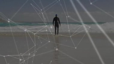 Kanal bağlantıları ile plajda yürüyen dalgıç kıyafetli biri. Teknoloji, yenilik, bağlantı, sörf, dijital, okyanus