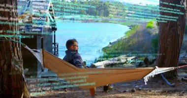 Hamakta göl kenarına uzanan bir adam programlama koduyla animasyonu örtüyor. Teknoloji, eğlence, kodlama, rahatlama, sükunet, dijital