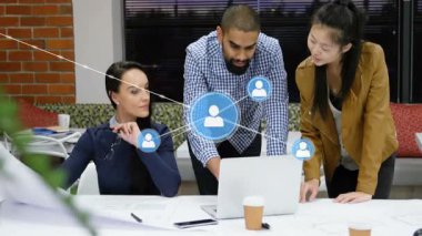Çalışma alanını kaplayan sosyal ağ simgeleriyle ofiste iş birliği yapan profesyoneller. Takım çalışması, ağ oluşturma, şirket, yenilik, teknoloji, iletişim