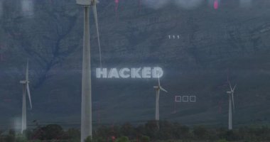 Dağlık arazide rüzgar türbinlerini kaplayan hacklenmiş metnin animasyonu. Siber güvenlik, yenilenebilir enerji, hackleme, dijital, teknoloji