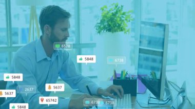 Masada çalışan, bilgisayar ekranını gizleyen sosyal medya bildirimleri alan bir adam. Teknoloji, çoklu görev, dijital, ofis, iletişim