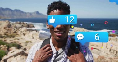 Okyanus kenarında yürürken, etrafındaki sosyal medya bildirimlerini gören bir adam. Doğa, açık hava, macera, keşif, teknoloji, bağlantı