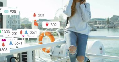 Rıhtımda, sosyal medya tebligatlarının animasyonuyla telefon kullanan bir kadın. Teknoloji, iletişim, bağlantı, ağ, akıllı telefon, dijital