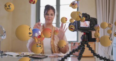 Kamera görüntüleyicisindeki kadın vlogger üzerindeki emoji simgeleri evde kayıt yapıyor. küresel sosyal medya, bağlantı ve iletişim konsepti dijital olarak oluşturulmuş görüntü.