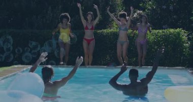 Yüzme havuzuna atlamak, bir grup arkadaş hareketli güneşli günün tadını çıkarıyor. Tatil, yaz, tatil, güneş, havuz başı, su sıçratma.