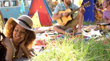 Konfeti düşmesi, arka planda renkli çadırlarla çimenlerin üzerinde dinlenen insanlar. Festival, kutlama, açık hava, eğlence, toplanma, coşku