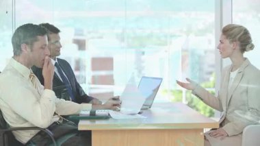 Ofiste, çeşitli profesyoneller masada dizüstü bilgisayarla iş toplantısını tartışıyor. Takım çalışması, işbirliği, beyin fırtınası, teknoloji, şirket, işyeri