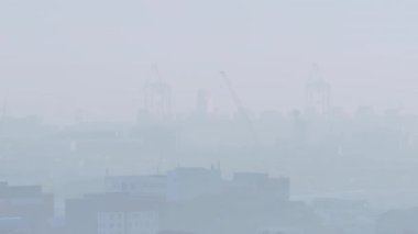 Arka planda vinçlerle, animasyon tarzında şehir manzarasında yüzen dev şeftali. Gerçeküstü, fantezi, kentsel, kaprisli, yaratıcı, fantezi manzarası