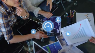 Dijital güvenlik simgeleriyle çizelgeleri analiz ediyorum. Toplantı odasında iş ekibi var. teknoloji, siber güvenlik, analitik, takım çalışması, işbirliği, beyin fırtınası