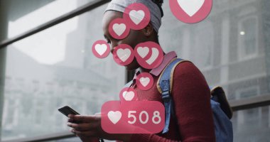 Sokakta akıllı telefon kullanan gülümseyen Afrikalı Amerikalı kadının sosyal medya kalp simgeleri. küresel iletişim teknolojisi ve sosyal ağ konsepti dijital olarak oluşturulmuş görüntü.