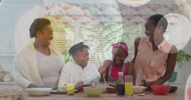 Afro-Amerikan ailesinin mutfakta birlikte yemek yediği görüntüler. Aile kalitesi, yemek pişirme ve yemek imajı.