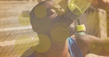 Sarı ışık noktaları, Afrika kökenli sağlıklı bir adamın su içmesine karşı. Spor, spor ve teknoloji konsepti