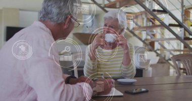 Evdeki Kafkasyalı yaşlı çiftin simgeleriyle olan bağlantılarının görüntüsü. küresel bağlantılar ve dijital arayüz konsepti dijital olarak oluşturulmuş görüntü.