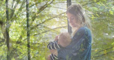 Kafkasyalı anne ve bebek süt içen güneş ışığı altındaki ağaçların görüntüsü. Anneler Günü ve annelik kavramı dijital olarak üretiliyor..