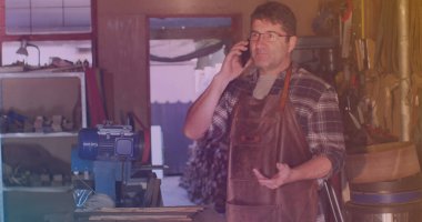 Kafkas erkek işçinin atölyede akıllı telefondan konuşması. iş ve iş konsepti dijital olarak oluşturuldu.