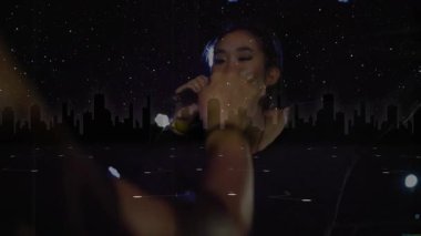 Sahnede performans sergileyen kadın şarkıcı dijital yıldız alanı ve şehir silueti ile müzik teknolojisi sergiliyor. Performans, eğlence, sahne, gece hayatı, gösteri, ışıklandırma, dijital