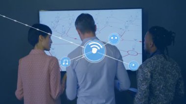 Ofisteki ağları inceleyen üç profesyonel tablet tutuyor ve yüzen dijital simgeleri gösteriyor. Teknoloji, işbirliği, yenilik, dijital, iletişim, fütüristik, iş