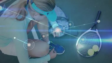 Kadın tenisçi, spor teknolojisi için sahada diz çöküp ağ kapaklarını gösteriyor. Sporcu, spor, dijital, teknoloji, açık hava, aktif, modern