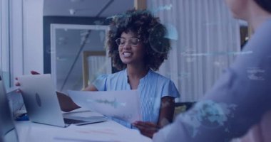 Ofisteki profesyoneller teknoloji ofisindeki kağıtları inceliyor, yüzen kodlar ve küresel grafikler sergiliyorlar. İşbirliği, takım çalışması, modern, idari, çalışma alanı, yenilikçi, üretkenlik