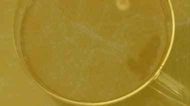 Cam bardak çaya krema dökerek üç boyutlu görüntüde girdap ve ışık yansımaları oluşturur. Minimalist, meşrubat, viskozite, zarafet, berraklık, soyutlama, sıcak tonlar