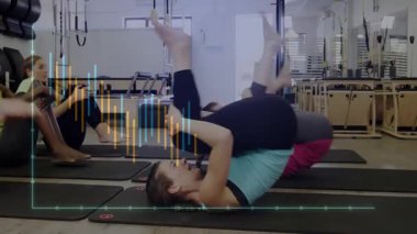 Grup pilates stüdyosunda dans ediyor ve hareketli performans çizelgeleriyle minderleri örtüyor. Spor, sağlık, güç, eğitim, biyomekanik, sağlık, hareket