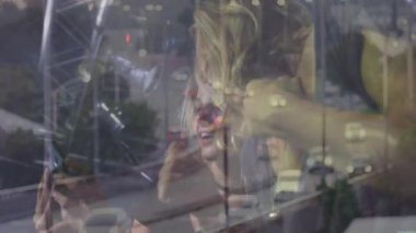 İki pazarlamacı kulüpte akıllı telefon selfie teknolojisi kullanıyor. Bokeh ışıkları ve şehir trafiği üst üste biniyor. Parti, gece hayatı, kutlama, şehir, canlı, arkadaşlık, teknoloji