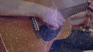 Kayıt stüdyosunda akustik gitar tıngırdatan erkek gitarist, kar örtüsü ve davul ikonu yer alıyor. Müzisyenler, işbirliği, akustik, ritim, performans, yaratıcı, sanatsal