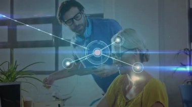 Kadın iş arkadaşı bilgisayar kullanırken erkek meslektaşı teknoloji ofisinde ağ verilerini inceliyor. İşbirliği, takım çalışması, dijital, yenilik, çalışma alanı, teknoloji, profesyonel