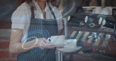 Kafede teknoloji arayüzü sunan bayan barista dairesel kadranlar ve diyagramlar gösteriyor. Teknoloji, yenilik, modern, gündelik, profesyonel, dijital, çalışma alanı