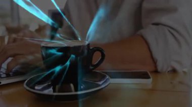 Kafedeki kahve fincanının yanında gümüş dizüstü bilgisayarda dijital ışık çizgileri olan bir adam. Teknolojik, modern, rahat, yaratıcı, çalışma alanı, dijital, üretkenlik